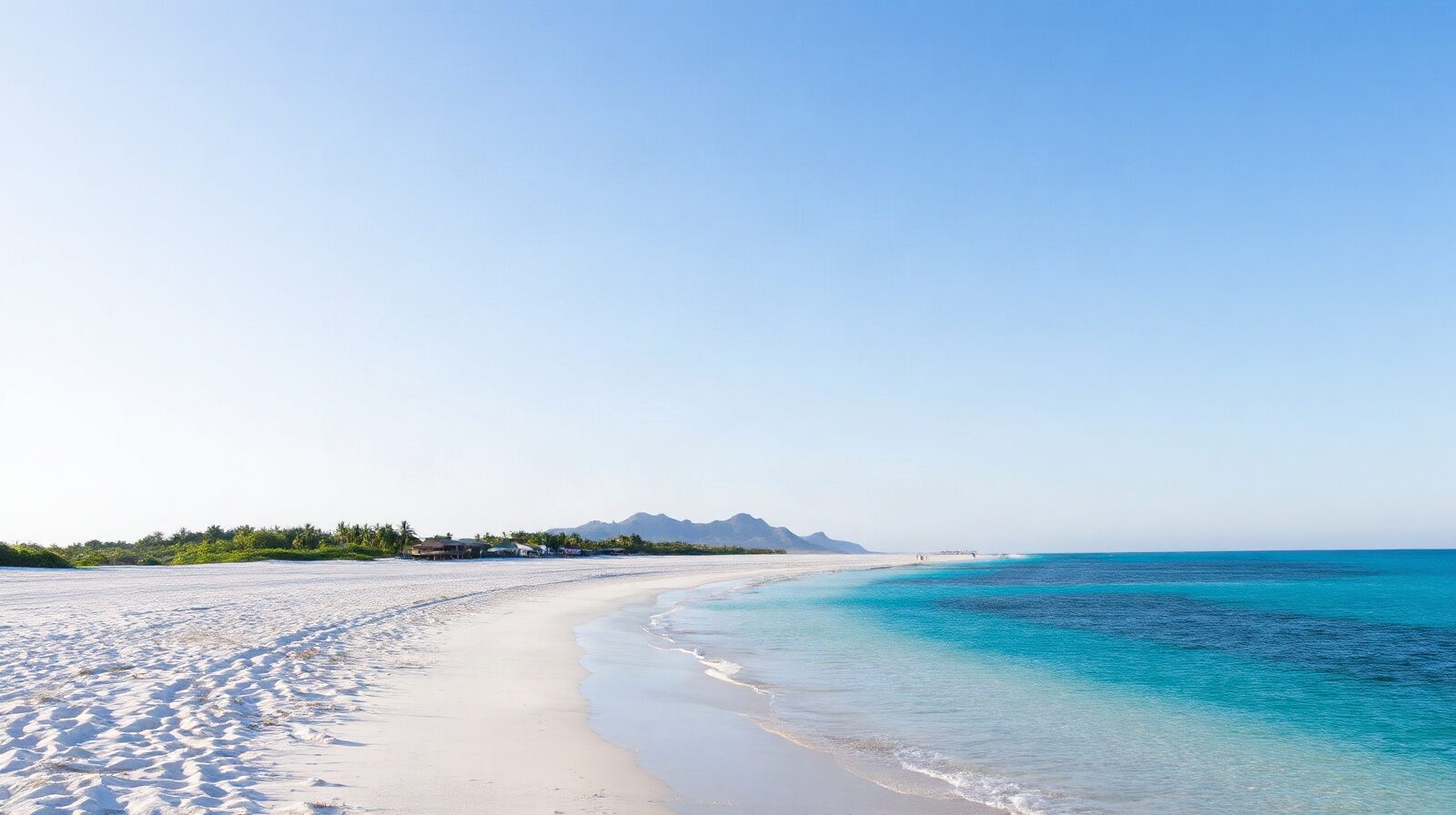Une longue plage bordée de raisiniers, avec une eau peu profonde